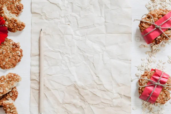 Gesunde vegane Haferkekse mit roten Blumen, Papier und Bleistift auf — Stockfoto