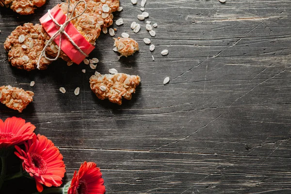 Çizilmiş bir ahşap masa üzerinde kırmızı çiçekli Anzak tanımlama bilgileri