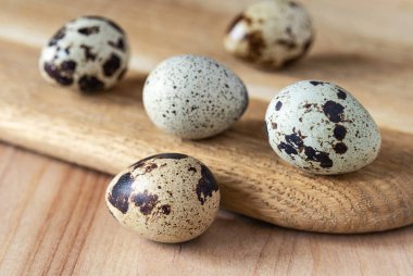 Ahşap mutfak tahtasındaki bıldırcın yumurtaları. Yiyecek ve içecek.