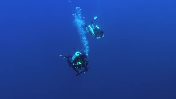 INDIAN OCEAN, MALDIVES, ASIA - MARCH 2018:  Two male scuba divers  swims in the deep blue water, Indian Ocean, Fuvahmulah island, Maldives