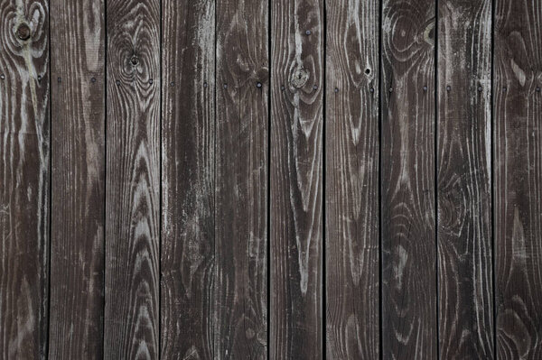 Old dark brown wooden wall background texture close up