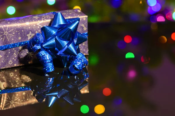 Blue ribbon ve süsleme ile bağlı kağıt ambalaj mor Noel hediyesi sarılı