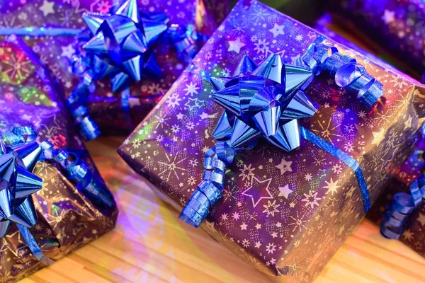 Blue ribbon ve süsleme ile bağlı kağıt ambalaj mor Noel hediyeleri sarılı