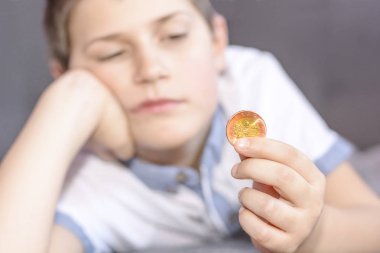 Küçük çocuk bir metal para elinde tutan