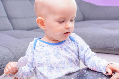 İlk doğum günü kutlaması küçük bir çocuk. Küçük çocuk doğum günü pastası bir kaşıkla yemek günün kutlu olsun. Yürümeye başlayan çocuk pasta ile masada. Küçük bebek smash doğum günü pastası. 