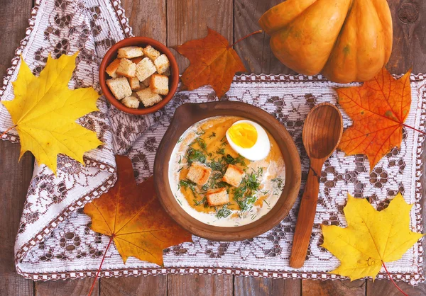 Pumpkin cream-soup decorated with maple leaves, boiled egg and c — Stock Photo, Image