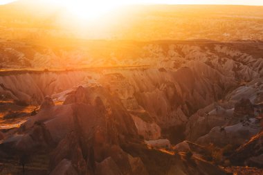 Geç sonbahar günbatımı ışınları, canlı doğal peyzaj Kapadokya'da.