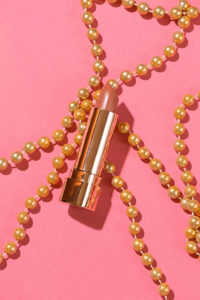 ピンクのビーズフラットレイで飾られたヌード弾丸口紅黄金のコンポーネント — ストック写真
