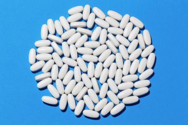 Tam kare beyaz oval hap dokusu mavi üzerine yatıyordu..