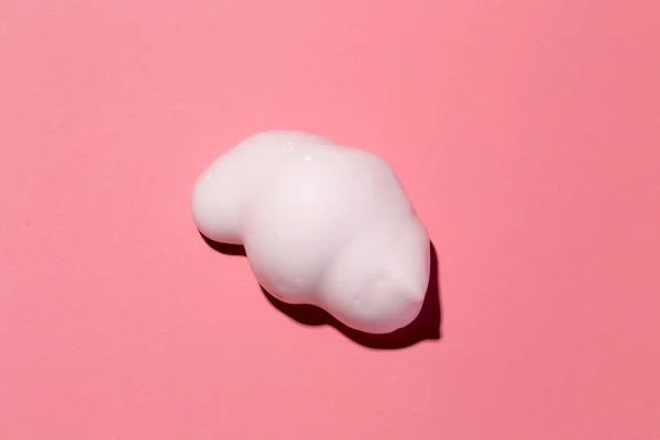 Pembe kağıt arka planda saç köpüğü parçası.