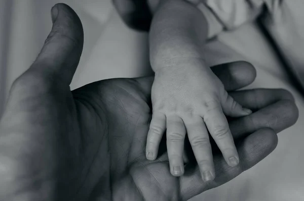 Дитяча рука в долоні батька — стокове фото