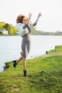 Kızıl saçlı genç kadın su sonbahar Parkı yürüme