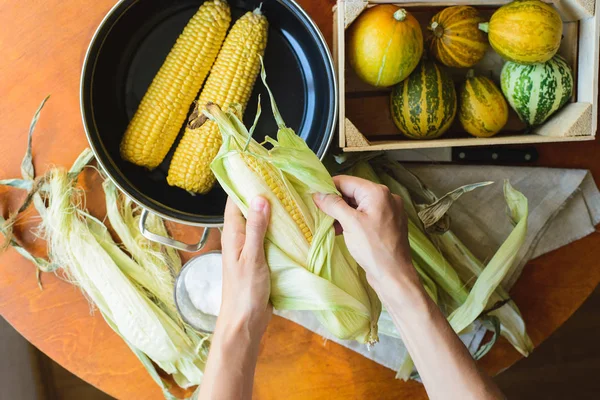 Верхний вид женщины готовит кукурузу для приготовления пищи в миске — стоковое фото