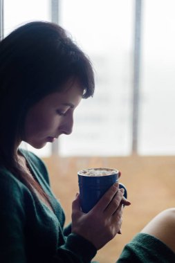 Kakaolu pencere üzerinde oturan kız