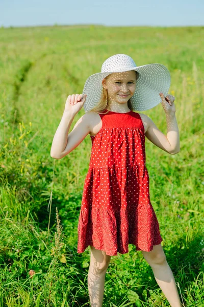 Девушка в красном платье и белой шляпе с большими краями — стоковое фото