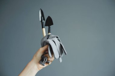 küçük kürek ve eldiven tutan el