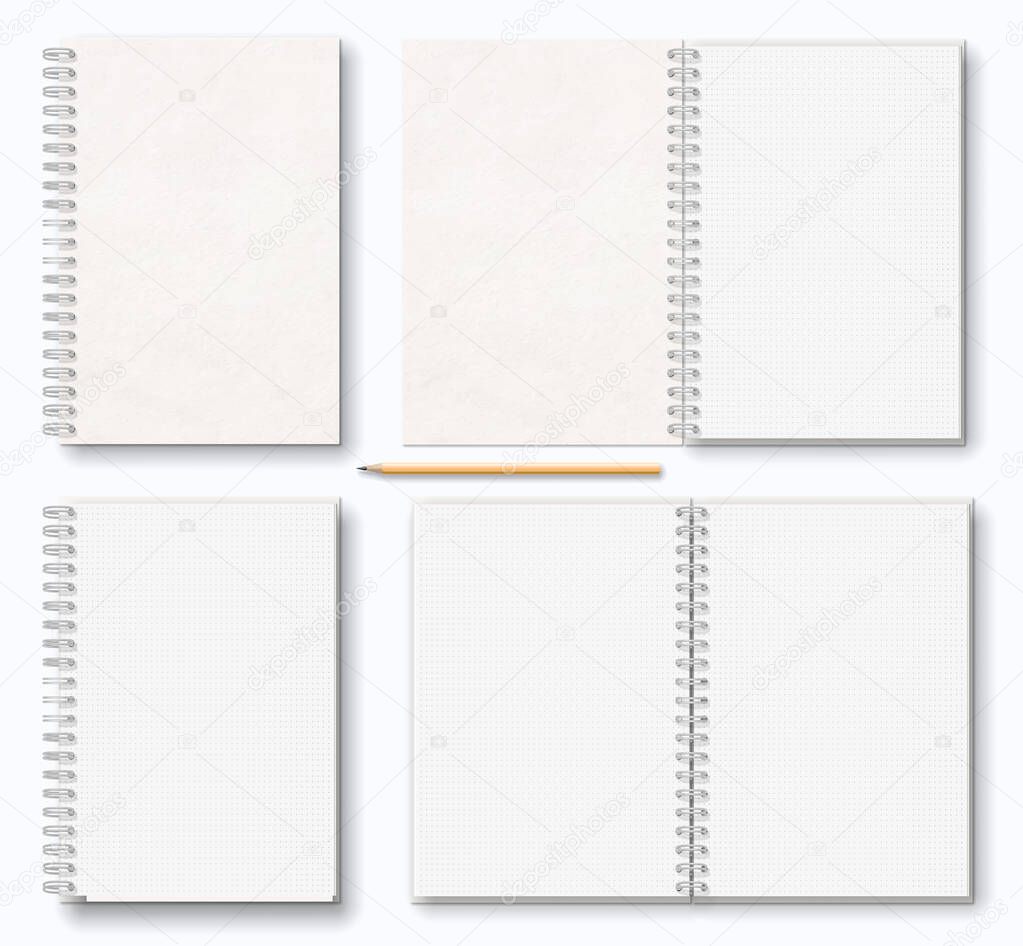 beige paper notebook with white metal spiral on left and wooden 
