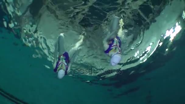 Onderwaterzicht van gesynchroniseerd zwemmen. — Stockvideo