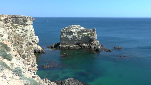 Roca caliza en forma de tortuga que se encuentra en el mar cerca del acantilado de la orilla . — Vídeo de stock