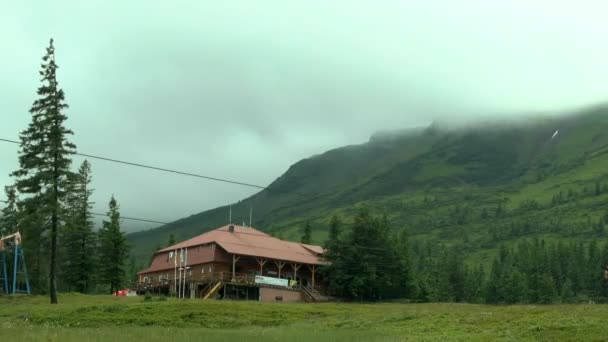 Movimiento de nubes sobre la montaña con el albergue en primer plano . — Vídeos de Stock