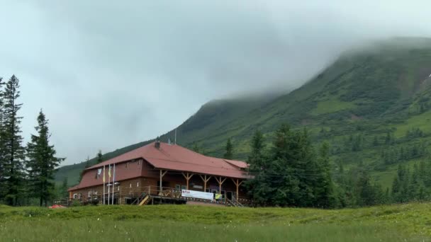 Κίνημα των νεφών πάνω από το βουνό με το hostel σε πρώτο πλάνο. — Αρχείο Βίντεο