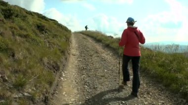 Bir kızla alpenstocks kadar dağ yoluna gider.