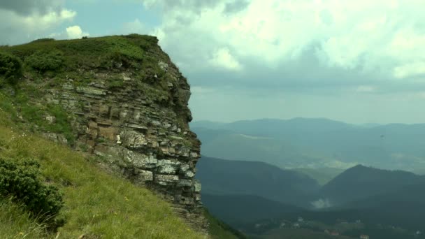 Malerischer Felsvorsprung gegen den wolkenverhangenen Himmel und eine Berglandschaft. — Stockvideo