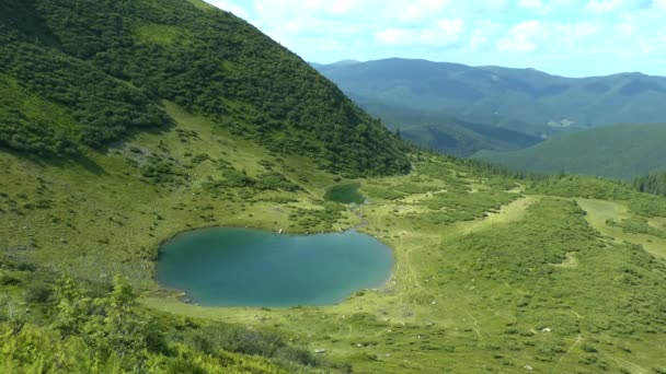 Pintoresco paisaje: un lago limpio contra las laderas de las montañas y los picos de las montañas . — Vídeos de Stock