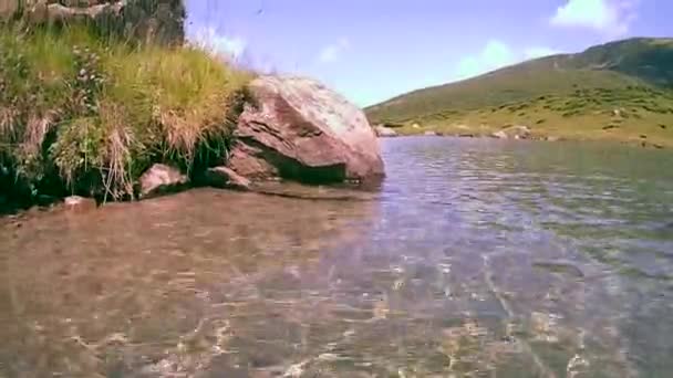 カメラは山の湖の水から上がり山のパノラマを取る. — ストック動画