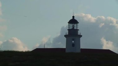 Hızlı uçan bulutların arkaplanına karşı deniz feneri, orta çekim.