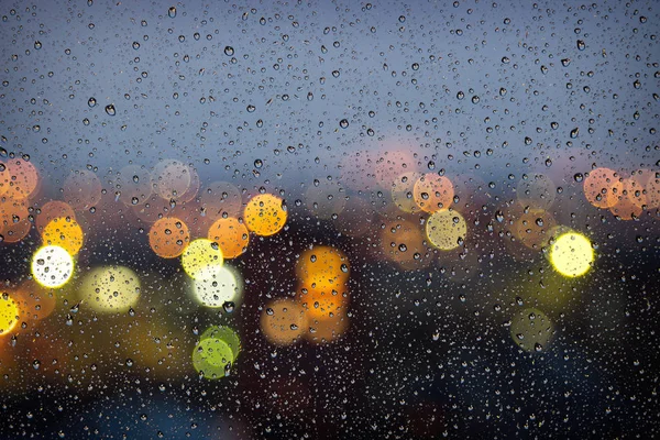Soyut bokeh ışıklar penceresindeki yağmur damlaları