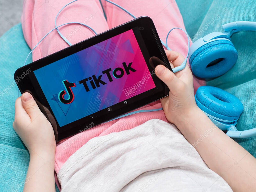 Chernigov, Ukraine, 21 of February, 2020. tablet in kids hands with Tik Tok icon on the screen. Tik Tok application icon on tablet asus screen close-up. tik tok application.