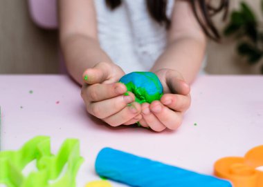 Çocuk elleri renkli kille oynuyor. Ev yapımı plastik. Plastiksin. Hamur oyna. Kil kalıbı yapan kız. Ev yapımı kil.