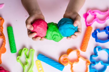 Çocuk elleri renkli kille oynuyor. Ev yapımı plastik. Plastiksin. Hamur oyna. Kil kalıbı yapan kız. Ev yapımı kil.