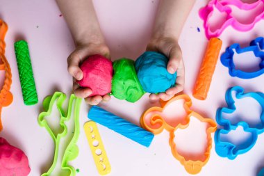 Çocuk elleri renkli kille oynuyor. Ev yapımı plastik. Plastiksin. Hamur oyna. Kil kalıbı yapan kız. Ev yapımı kil.