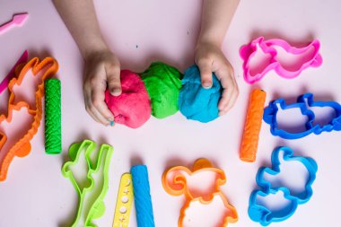 Çocuk elleri renkli kille oynuyor. Ev yapımı plastik. Plastiksin. Hamur oyna. Kil kalıbı yapan kız. Ev yapımı kil.