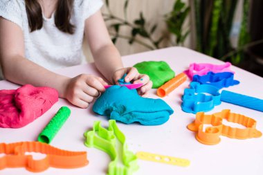 Çocuk elleri renkli kille oynuyor. Ev yapımı plastik. Plastiksin. Hamur oyna. Kil kalıbı yapan kız. Ev yapımı kil.