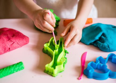 Çocuk elleri renkli kille oynuyor. Ev yapımı plastik. Plastiksin. Hamur oyna. Kil kalıbı yapan kız. Ev yapımı kil.