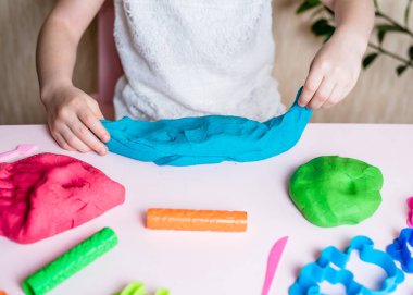 Çocuk elleri renkli kille oynuyor. Ev yapımı plastik. Plastiksin. Hamur oyna. Kil kalıbı yapan kız. Ev yapımı kil.