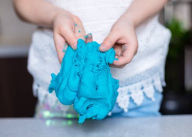 Çocuk elleri renkli kille oynuyor. Ev yapımı plastik. Plastiksin. Hamur oyna. Kil kalıbı yapan kız. Ev yapımı kil.