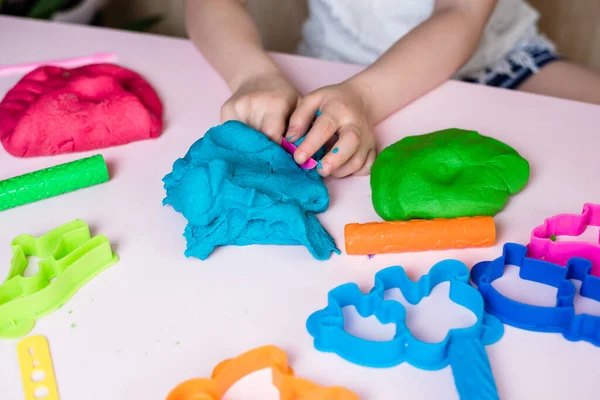 Çocuk elleri renkli kille oynuyor. Ev yapımı plastik. Plastiksin. Hamur oyna. Kil kalıbı yapan kız. Ev yapımı kil.