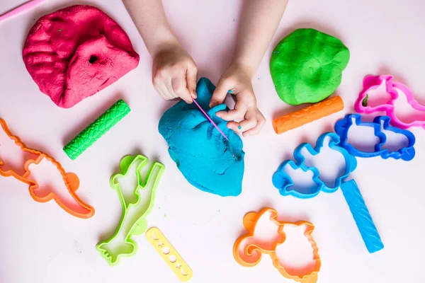 Çocuk elleri renkli kille oynuyor. Ev yapımı plastik. Plastiksin. Hamur oyna. Kil kalıbı yapan kız. Ev yapımı kil.