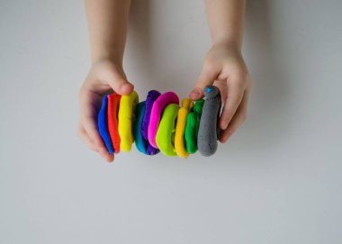 Çocuk elleri renkli kille oynuyor. Ev yapımı plastik.