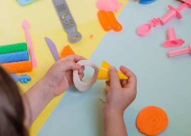 Çocuk elleri renkli kille oynuyor. Ev yapımı plastik.