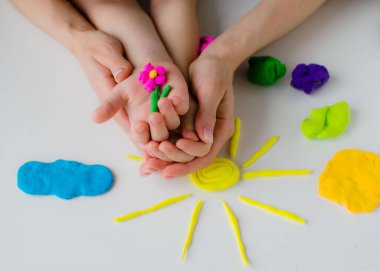 Çocuk elleri renkli kille oynuyor. Ev yapımı plastik.