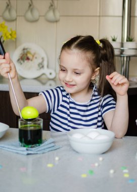 Paskalya konsepti. Paskalya için hazırlanıyor. Küçük kız Paskalya için yumurta boyuyor.