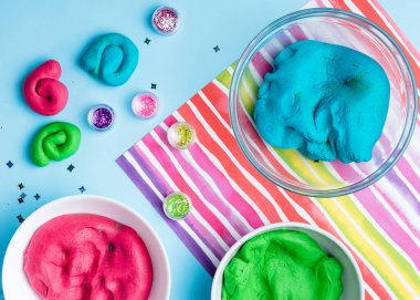 Ev yapımı plasticin, plasticin, simli renkli bir arka planda hamur oyunu. Kil ya da balçık kalıbı. Ev yapımı kil.