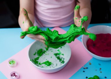 Çocuk elleri renkli kille oynuyor. Ev yapımı plastik. Plastiksin. Hamur oyna. Kil kalıbı yapan kız. Ev yapımı kil.