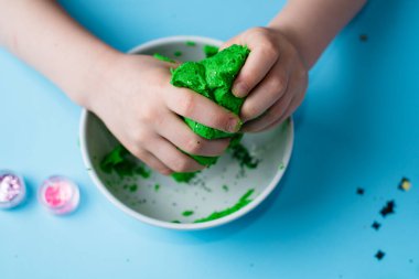 Çocuk elleri renkli kille oynuyor. Ev yapımı plastik. Plastiksin. Hamur oyna. Kil kalıbı yapan kız. Ev yapımı kil.