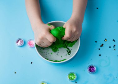 Çocuk elleri renkli kille oynuyor. Ev yapımı plastik. Plastiksin. Hamur oyna. Kil kalıbı yapan kız. Ev yapımı kil.